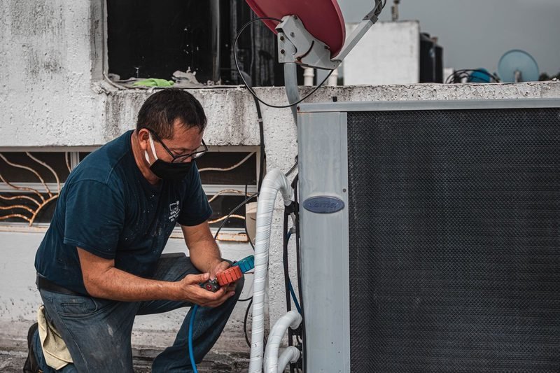 HVAC technician servicing AC unit