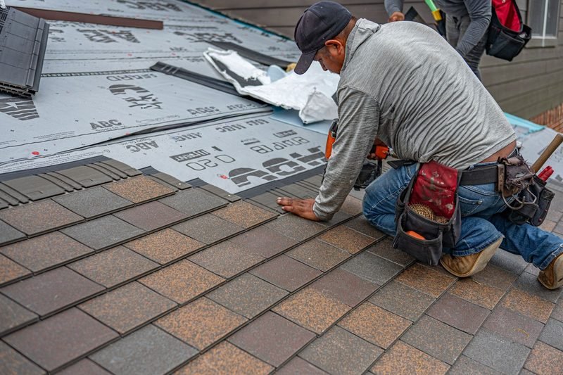 Roofer installing shingles